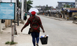 A woman sells drinks on the street as Lagos State conducts elections for its 20 Local Gove...
