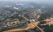 Trucks pass a bridge in an area of polluted water contaminated by a nickel mine near the I...