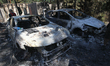 Burnt-out cars are among the rubble after a Russian drone attack in a suburb of Dnipro, Uk...