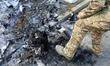 A man in a camouflage uniform stands by an engine after a Russian missile and drone strike...