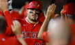 Los Angeles Angels' Mike Trout (27) is congratulated after scoring during the third inning...