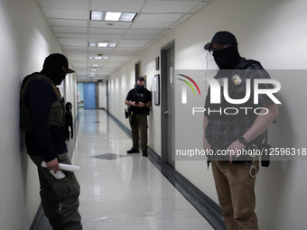 Federal officers scrutinize the hallways of the Immigration court office areas at the Jakob Javits Federal Builing in Lower Manhattan on Jul... by John Lamparski/NurPhoto