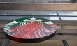 Red paint splashes across the sign of the Starbucks coffee shop adjacent to The New York T...