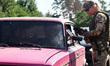 A border guard checks the driver's papers at one of the checkpoints on the outskirts of Kh...