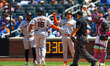 Rafael Devers of the San Francisco Giants is congratulated at home plate after hitting a t...