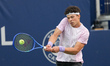 Ben Shelton of the United States plays a backhand against Flavio Cobolli of Italy during t...