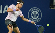 Ben Shelton of the United States plays a forehand against Alex De Minaur of Australia duri...