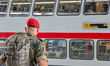A German Bundeswehr soldier wearing a red beret stands on the platform as an Intercity tra...