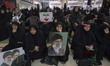 A veiled Iranian woman holds a portrait of Iran's Supreme Leader, Ayatollah Ali Khamenei,...