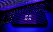 Binary code displayed on a laptop screen displayed on a laptop screen and Zoox logo displa...