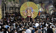 Devotees gather as a large idol of the Hindu god Ganesha is carried through a street durin...