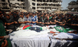 Mourners pray during a group funeral for Palestinians, including journalists and a medic,...