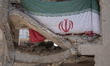 An Iranian flag hangs on a building targeted during Israeli attacks on a residential area...