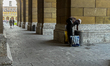 A man with plastic bags collects deposit bottles from a public trash in Munich, Germany, o...