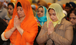 Sikh women offer prayers at a gurdwara (Sikh Temple) during Vaisakhi in Toronto, Ontario,...