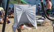 A boy sleeps under a towel wrapped around a swing on Bezmezh Accessible Beach by the Black...