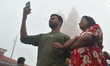 Hindu devotees stand next to a large Hanuman idol in Kurseong, Darjeeling, West Bengal, In...