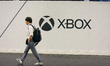 A fairgoer walks past an Xbox sign at the Cologne trade fair center during the opening day...