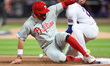 Philadelphia Phillies player Kyle Schwarber (12) slides into third base during the third i...