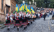 Members of the Merited Academic Zakarpattia Folk Choir walk ahead of citizens, priests, an...