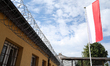 A wall with razor wire and the Polish flag is at the Nowa Huta Prison in Krakow, Poland, o...