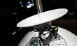A satellite dish with leveling equipment is installed outdoors, showing precise alignment...