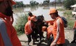 State disaster response teams prepare to rescue people from the submerged residential hous...