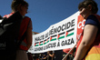 The banner reads 'Stop the genocide, Remove the blockade of Gaza'. A Senior EU official, T...