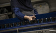 An Iranian female laborer checks the bottles of soft drinks as she works on the energy dri...