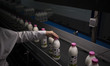 An Iranian female laborer checks the bottles of milk as she works on the dairy production...
