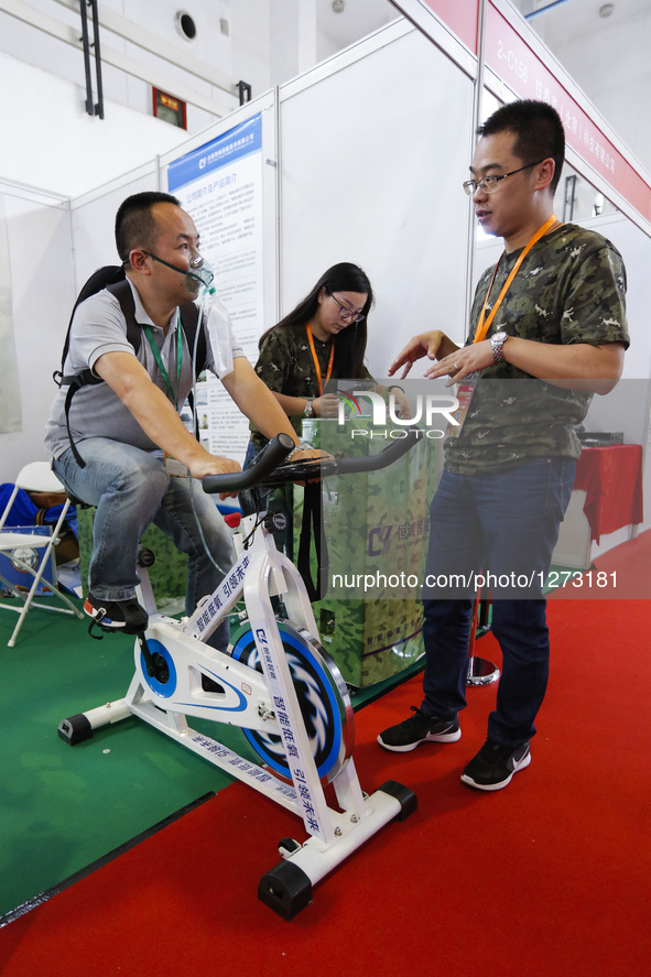 A cyclist tries a high-altitude training system at Chinese Defense Information Equipment & Technology Exhibition 2016 (CNTE2016) in Beijing,...