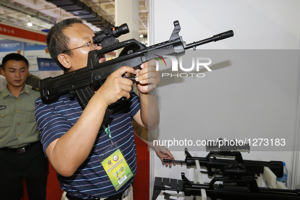A visitor tries a gun targeting system at Chinese Defense Information Equipment & Technology Exhibition 2016 (CNTE2016) in Beijing, capital...