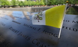 A flag is placed on the name on the South Pool, one of two reflecting pools at the Nationa...
