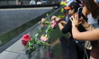 Flowers are placed on the names on the panel of the South Pool, one of two reflecting pool...
