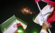 Iranians wave the country's flags while fireworks occur during a religious rally commemora...