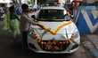 A driver decorates his taxi to celebrate the festival of Vishwakarma Puja, the festival of...