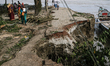 Locals walk along an eroded bank of the Padma River in Jajira, Shariatpur, Bangladesh, on...