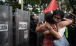 Two people hug in front of riot police during a rally near the Israeli Embassy in Mexico C...