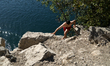 Young men jump from rocks into the water at the Zakrzowek Reservoir in Krakow, Poland, on...