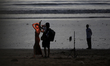 A photographer clicks a photograph of a model at a sea beach in Mumbai, India, on Septembe...