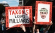 Protesters hold placards as they march during the demonstration ''Climate, Justice, Freedo...