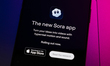 The Sora App home page displays on a smartphone screen placed on a computer keyboard illum...
