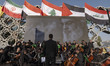Iranian musicians from the Sarv Symphonic Orchestra prepare to perform under a portrait of...