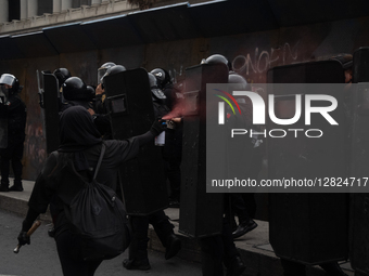An anarchist sprays against police during a protest commemorating the 57th anniversary of the 1968 Student Massacre at the Plaza de las Tres... by Eyepix/NurPhoto