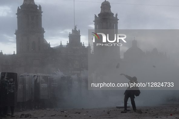 An anarchist throws a stone at riot police during a protest commemorating the 57th anniversary of the 1968 Student Massacre at the Plaza de...