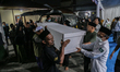 In Surabaya, Indonesia, on October 6, 2025, officers, family, and relatives carry victim c...
