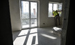 A builder looks out a window in an apartment block at 2A Zaporizka Street, where one secti...