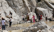 Nepali travelers walk across the cliffs as they navigate the flooded section of the BP Hig...