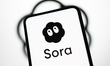 The Sora app logo appears on a smartphone screen with the OpenAI logo in the background. O...