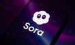 The Sora app logo appears on a smartphone screen, reflecting an abstract illustration in p...